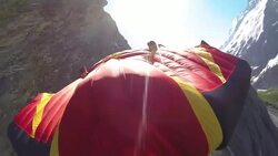 POV wingsuit flying down a cliff face Stock Footage