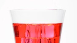 rotation: ice in top of red water glass Stock Footage