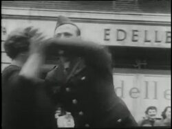British and American flags wave as hundred of citizens, soldiers, men, and women gather together dancing and cheering celebrating VE Day in Trafalgar Square in London. News Clip