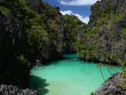 "WS PAN of idyllic tropical lagoon surrounded by plants and sharp limestone cliffs / Small Lagoon, Miniloc Island, Bacuit Archipelago, El Nido, Palawan, Philippines " Stock Footage