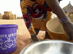 CU, Woman mixing millet grain in bowl, low section, Niamey, Niger Stock Footage
