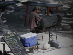 Man grills on the beach in Belize Stock Footage