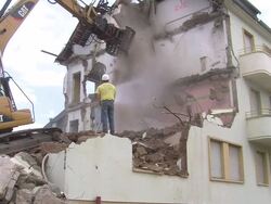 MS Demolition of apartment block and man watering / Saarburg, Rhineland-Palatinate, Germany Stock Footage