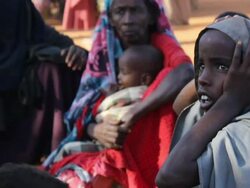 Refugee child sitting with family at refugee camp Stock Footage