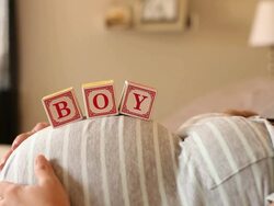 A pregnant women using blocks to spell the word BOY on her stomach. Stock Footage