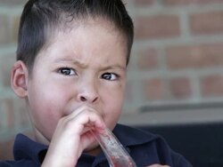 Latino boy sucking on an Otter Pop Stock Footage