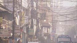 Utility lines hang above a street crowded with pedestrians and pedicabs. Stock Footage
