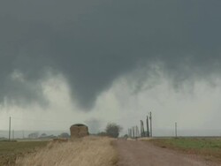 WS ZO View of cone shaped tornado tracks behind stack of hay and over road / Tillman County, Oklahoma, United States Stock Footage