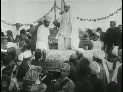 Mahatma Gandhi teaches a group of people in a village in India. News Clip
