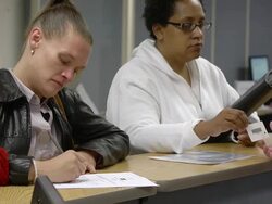 MS Job seekers women  standing at counter and being assisted by clerk at state run job center / Jackson, Michigan, United States  Stock Footage