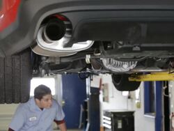 MS Mechanic walking into auto shop and pick up wrench and starts working under car / Seattle, Washington, United States  Stock Footage