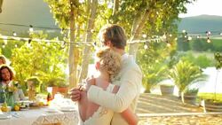 Hugging bride and groom turning to friends at wedding reception Stock Footage