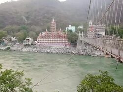 WS PAN View of Lakshman Jhula with holy city at waterfront / Rishikesh, Uttarakhand, India Stock Footage