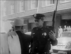 B/W 1963 man in hat talking to policeman with gun looking up / Kennedy assassination / Dallas Stock Footage