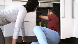 Young couple talking while repairing sink Stock Footage