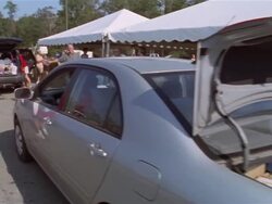 September 2005 Woman driving car with open trunk up to Hurricane Katrina relief center / volunteers loading truck with supplies / Mississippi Stock Footage