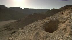 A hazy sky outlines a mountain ridge beyond an abandoned emerald mine in the ancient city of Sikait, Egypt. Stock Footage