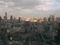T/L WA High angle view across London skyline, Clouds passing overhead cast shadows below, day to dusk, pan left Stock Footage
