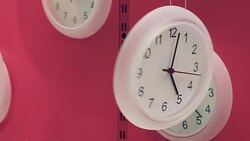 Clocks hanging on pink background Stock Footage