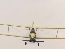 Shot of crop duster airplane flying by and releasing the pesticides. Stock Footage