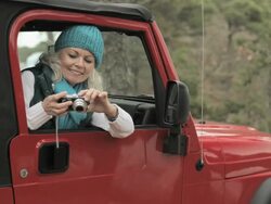 Senior woman in vehicle using digital camera Stock Footage