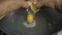 hands opening broken eggshell of brown raw egg Stock Footage
