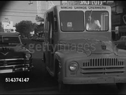 1952: NEVADA: DAWN: WS Sunrise behind mountains in desert. LAS VEGAS: MS Front of Rancho Grande Creamery dairy delivery truck double parking, male driver carrying crate of milk, casino workers walking outside, smoking cigarette. Instructional Video