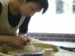 MS Shot of female potter are sharpened bowl with pottery wheel in studio / Kyoto, Japan Stock Footage