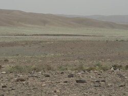 Wind blows the small tufts of grass growing from the stark land. Stock Footage