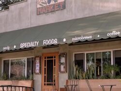TD exterior establishing shot of neighborhood market and coffee house social gathering place in building from 1920s / Redlands, California, USA Stock Footage