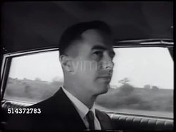 1966: FARMVILLE, NORTH CAROLINA: WS (POV Moving vehicle) Passing parking lot of industrial rural business complex, MS Ed Davenport driving car,  Ws Passing Farmville Farm Supplies business complex, tall building & tanks like grain elevators behind. Instructional Video