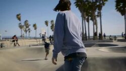 teenager skating around venice skatepark filming with phone Stock Footage