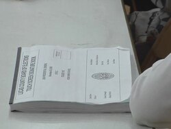 CU, Person sitting by registration sign up book on tabletop at polling place, Toledo, Ohio, USA Stock Footage