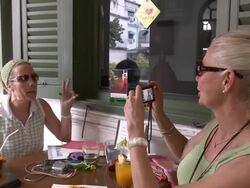 ZI CU Woman photographing friend at outdoors cafe table, Bangkok, Thailand Stock Footage