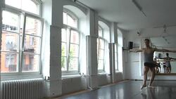 Young male ballet dancer doing a split in rehearsal room Stock Footage