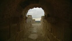 An arched tunnel frames the countryside at the Oudna Amphitheater ruins in Tunisia. Stock Footage