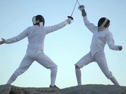 A man and woman fencing on the beach. - Slow Motion Stock Footage