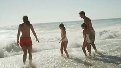 Family jumping waves in ocean surf Stock Footage