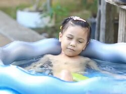 asia girl  playing in a paddling pool Stock Footage