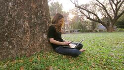 girl using smartphone and laptop on her knee Stock Footage