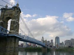 WS T/L View of John A.Roebling Suspension Bridge on river with Cincinnati skyline in background / Cincinnati, Ohio, United States Stock Footage