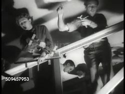 1936: U.S. THEATRE: MARIONETTE PUPPETS: WS Parents & children entering theatre, canopy marquee 'The Magic Strings.' HA WS String puppets on stage. LA MS Puppeteers working. VS Puppets dancing, children in audience, puppets dancing, curtains close. Instructional Video