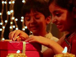 Boy and girl opening a gift box in diwali festival Stock Footage