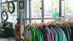 Small business owner unlocks store and walks bicycle into shop Stock Footage