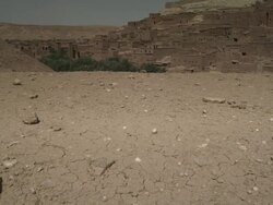 Dry, cracked land gives way to rugged buildings built into the landscape. Stock Footage