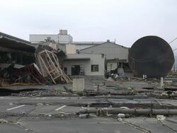 Destruction caused by tsunami after magnitude 9 Tohoku earthquake, north east Japan, March 2011. Huge oil storage tank lies on its side against industrial building in Ishinomaki City port, Miyagi Prefecture Stock Footage