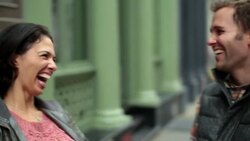 Happy New York couple walk hand-in-hand up Soho sidewalk, boyfriend stops to pull girl in for kiss Stock Footage
