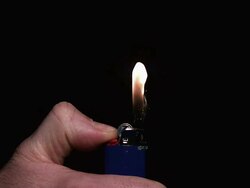 MS SLO MO Hand lighting flame in lighter / Vieux Pont, Normandy, France Stock Footage