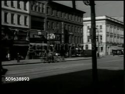 1941: THE NEW ORDER: FICTIONAL DRAMATIZATION: Man walking up deserted sidewalk in northern city. WS Horse & buggy parked curbside in front of store, almost deserted downtown area. Deserted sidewalk lined w/ shops, Tom McAn shoe store & store For Rent Instructional Video