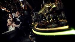 Glamorous couple sip from champagne glasses in limo amidst a barrage of flash photography at awards show Stock Footage